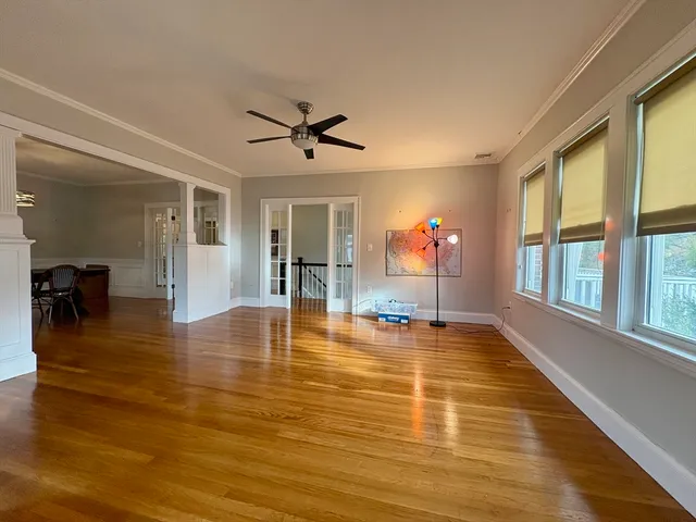 a view of empty room with wooden floor and fan