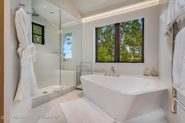 a bathroom with a tub sink and mirror