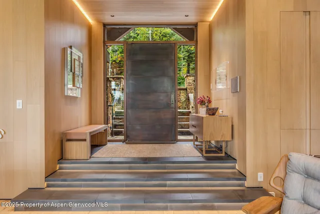a view of a hallway with wooden floor and a large mirror