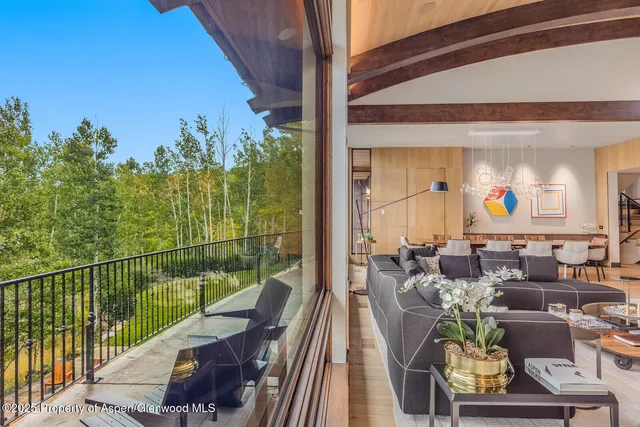 a dining room with furniture a flat screen tv and a large window