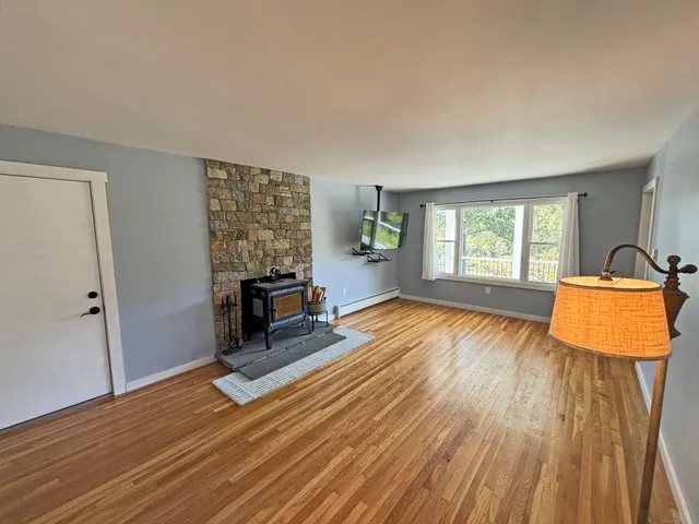 an empty room with windows and wooden floor