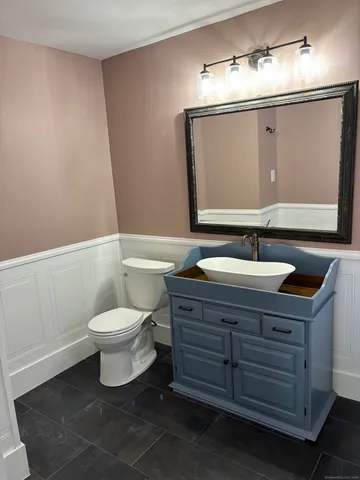 a bathroom with a sink a toilet and mirror
