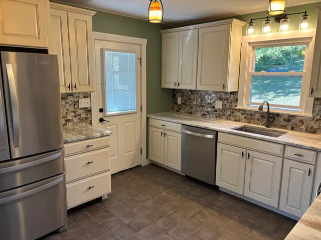 a kitchen with white cabinets and white appliances