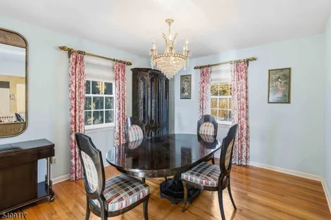 a dining room with furniture a chandelier and wooden floor