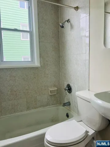 a white toilet and a bath tub sitting in a bathroom