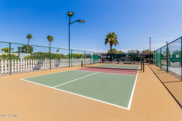 a sign board with a house in the background