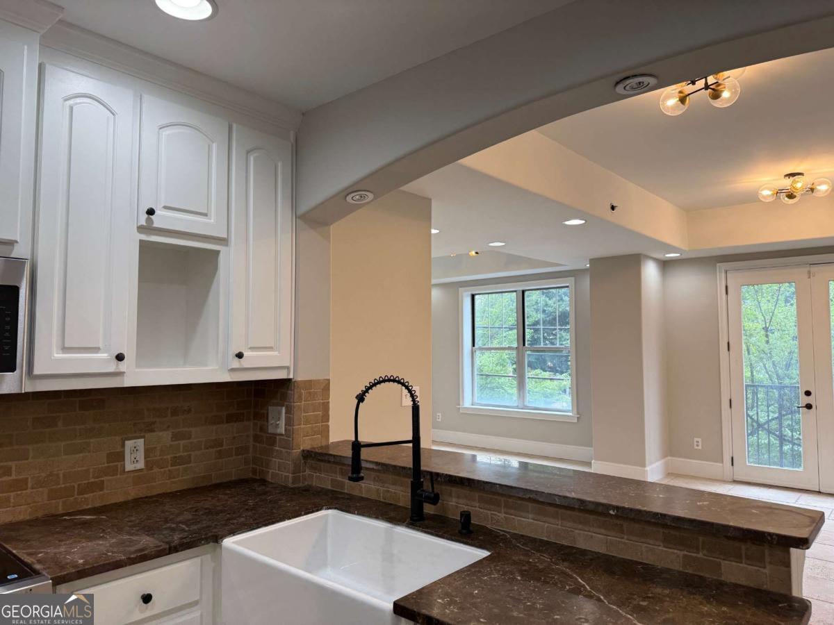 2255 Peachtree Road Northeast, Unit 322 Atlanta, GA 30305 - Photo 11 of 31 a kitchen with granite countertop a stove a sink and a microwave