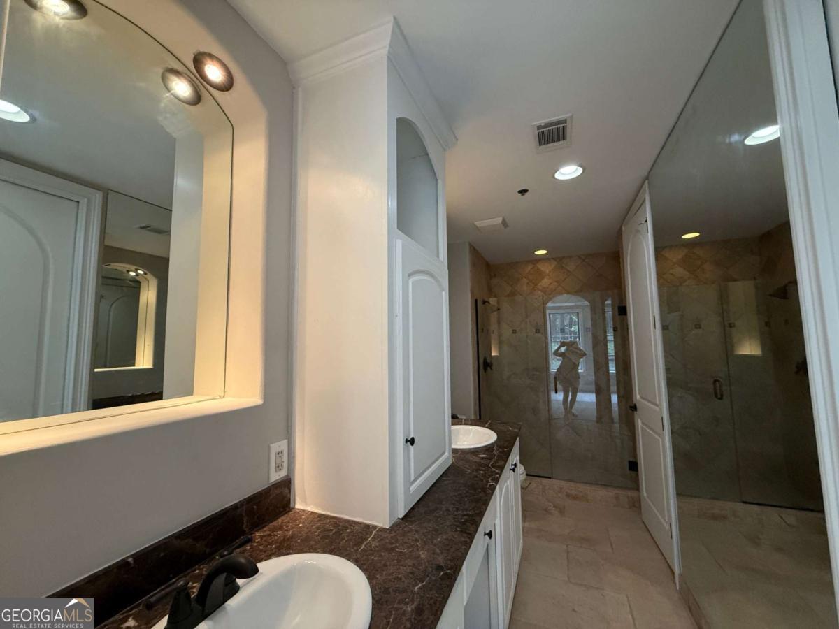 2255 Peachtree Road Northeast, Unit 322 Atlanta, GA 30305 - Photo 15 of 31 a bathroom with a sink and mirror