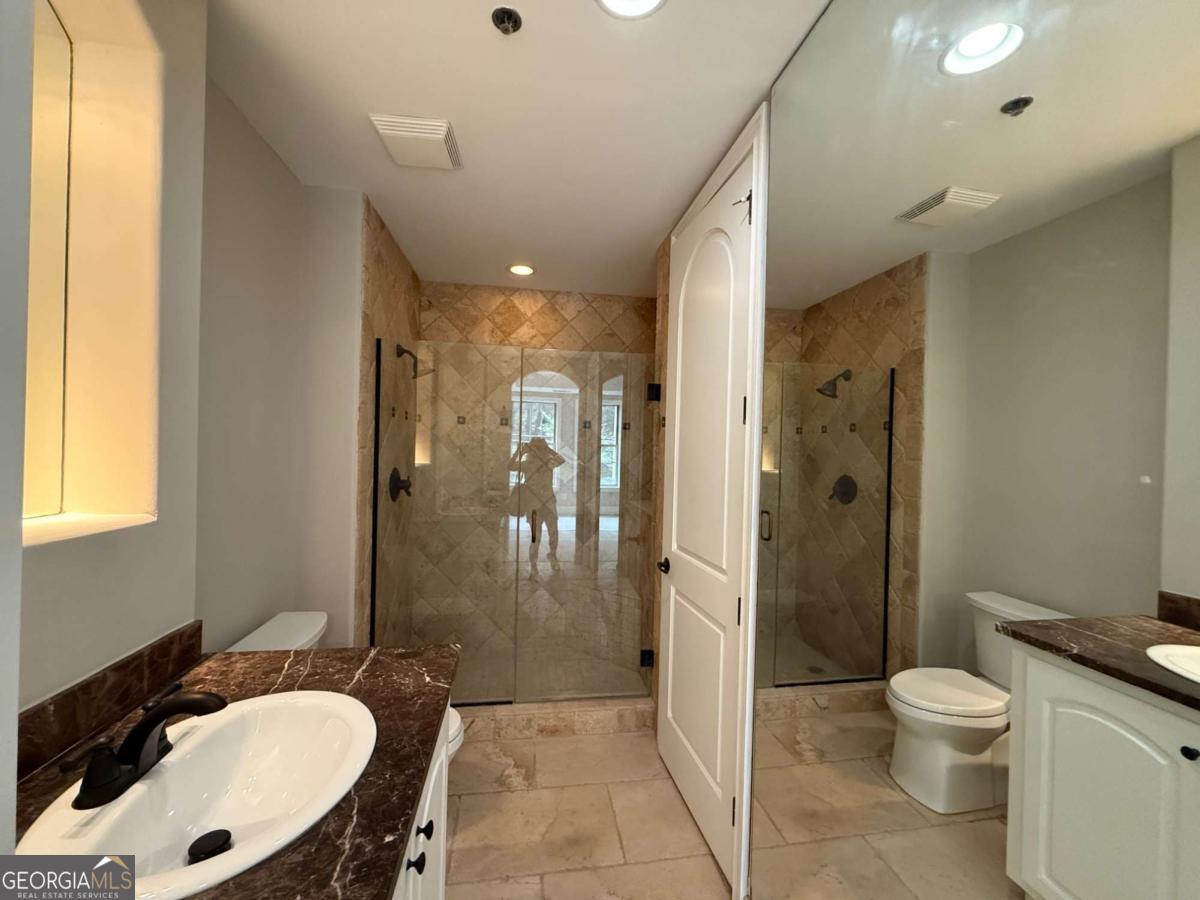 2255 Peachtree Road Northeast, Unit 322 Atlanta, GA 30305 - Photo 16 of 31 a bathroom with a sink a toilet a mirror and shower