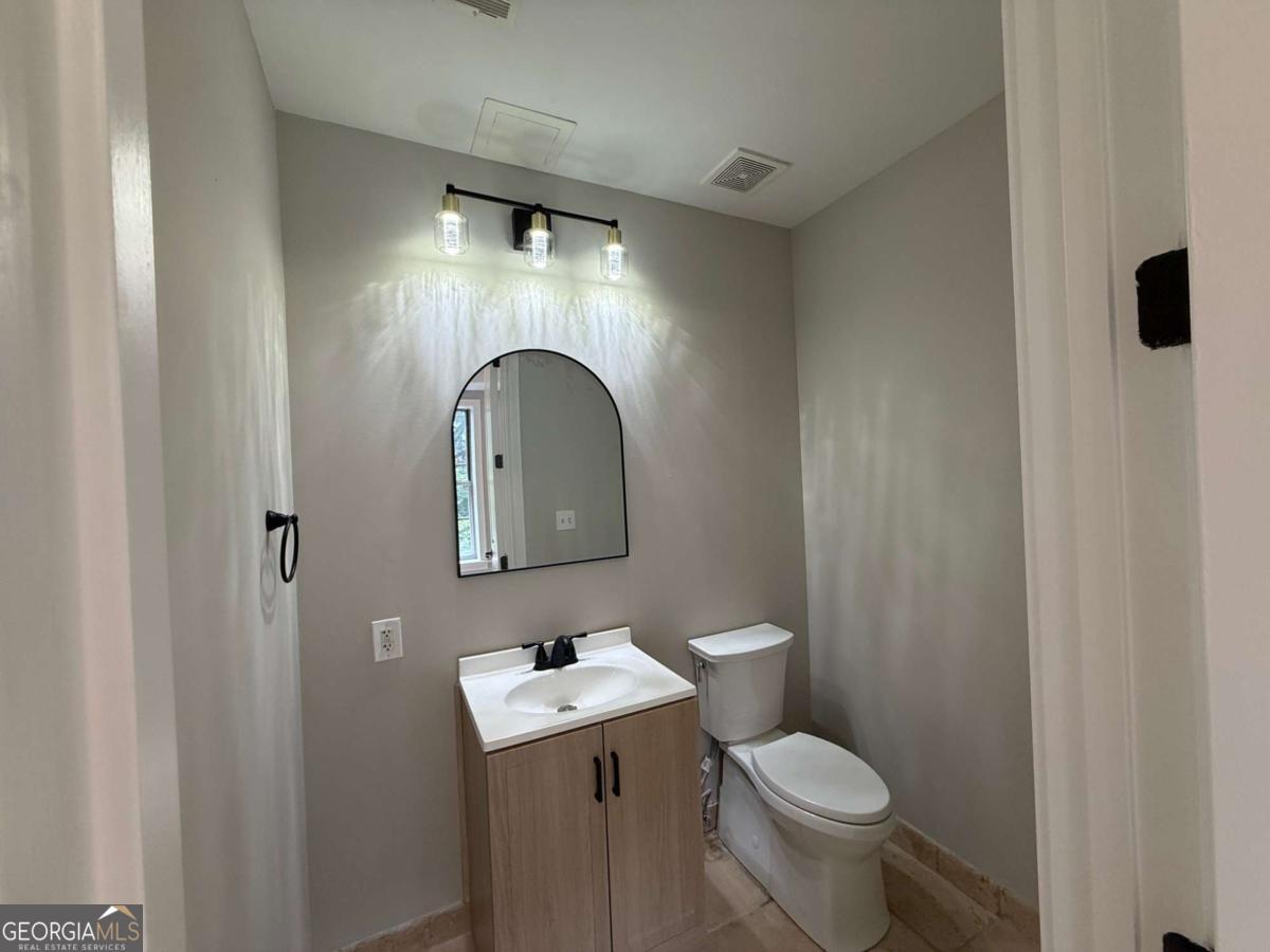 2255 Peachtree Road Northeast, Unit 322 Atlanta, GA 30305 - Photo 20 of 31 a bathroom with a toilet sink and mirror