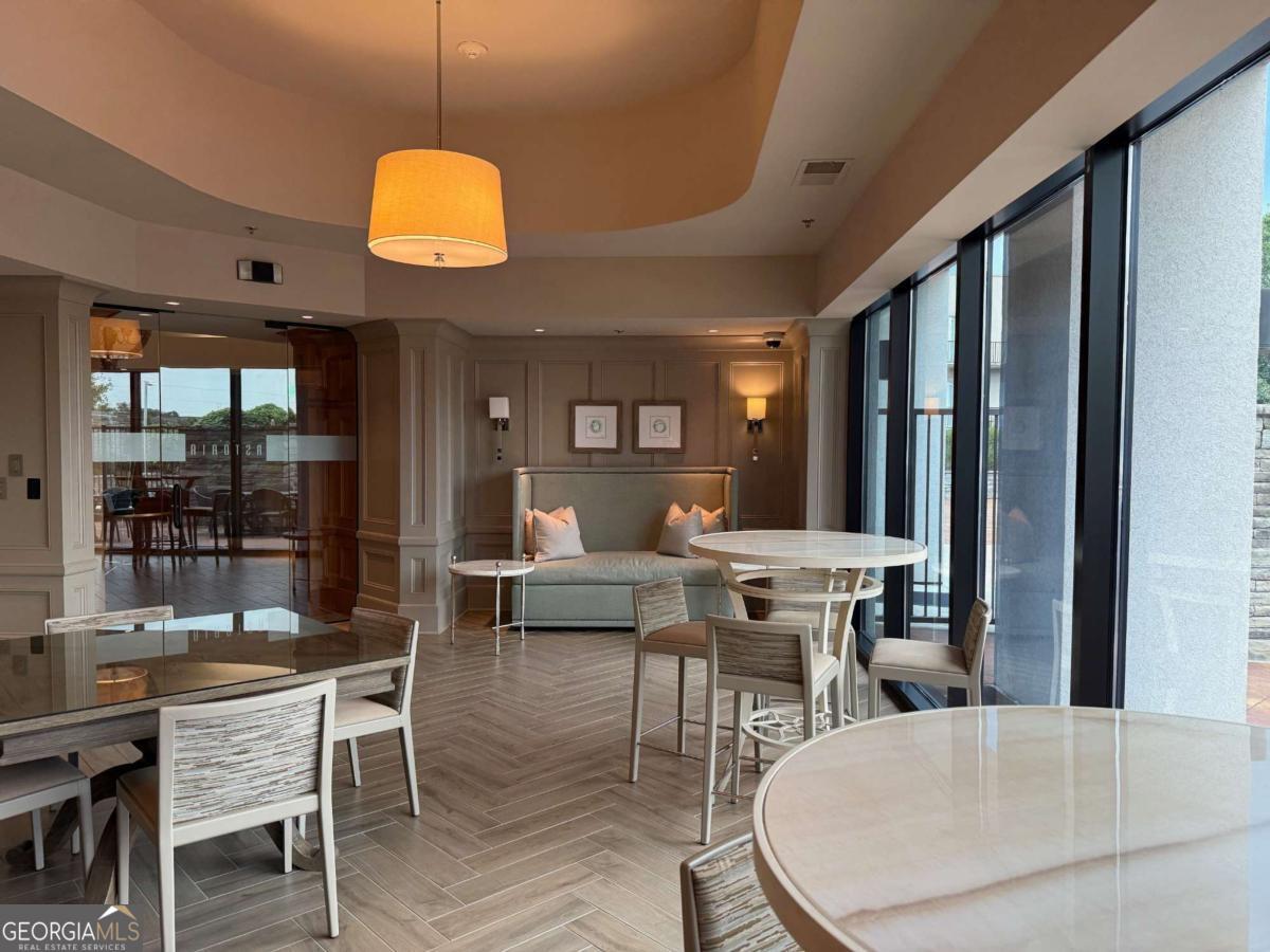 2255 Peachtree Road Northeast, Unit 322 Atlanta, GA 30305 - Photo 30 of 31 a dining room with wooden floor a glass table and chairs