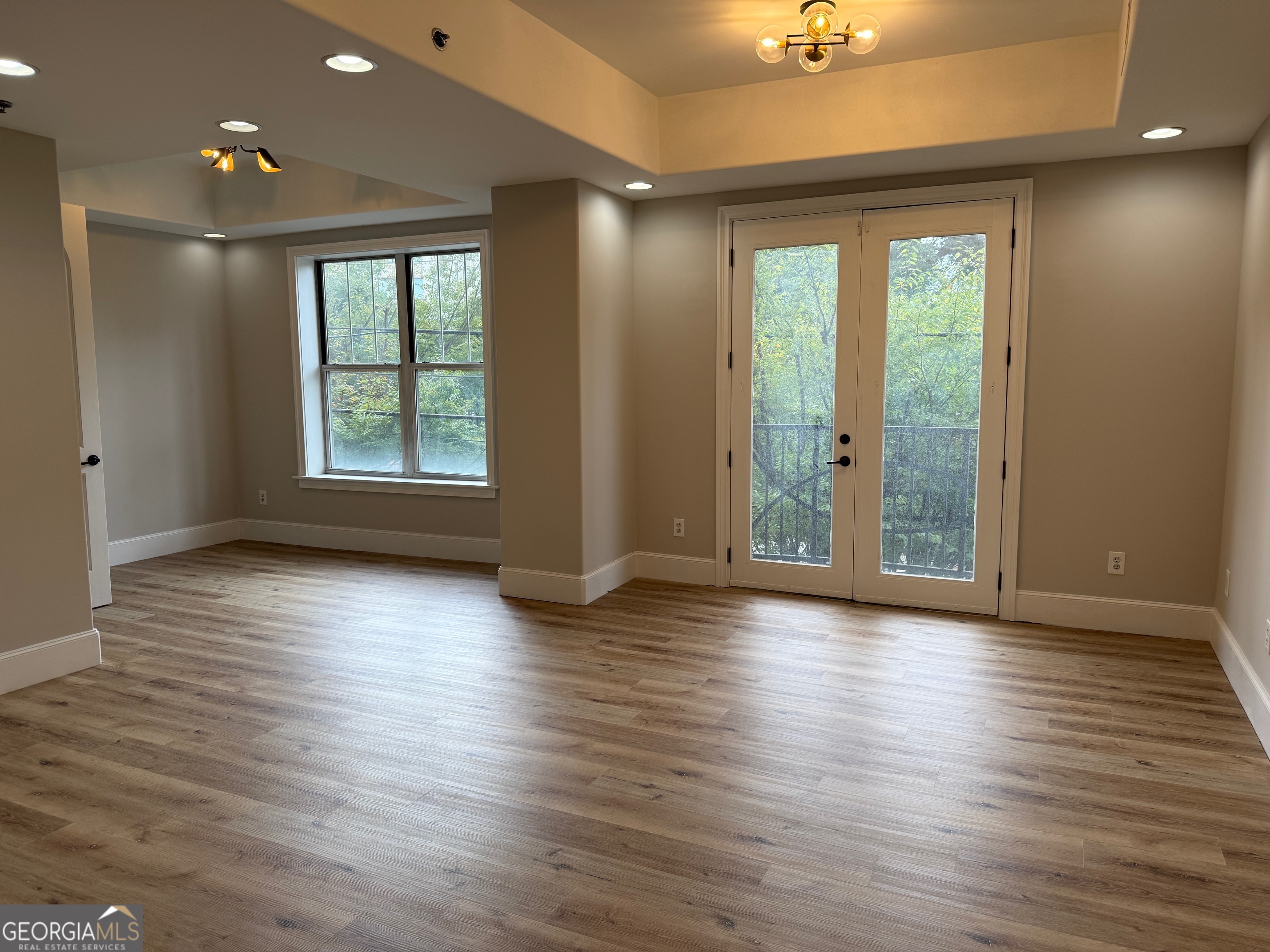 2255 Peachtree Road Northeast, Unit 322 Atlanta, GA 30305 - Photo 5 of 31 an empty room with wooden floor and windows