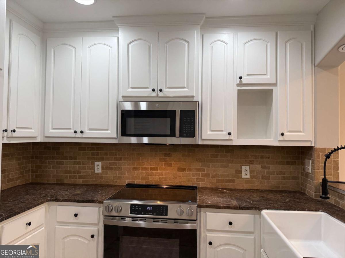 2255 Peachtree Road Northeast, Unit 322 Atlanta, GA 30305 - Photo 8 of 31 a kitchen with white cabinets and sink