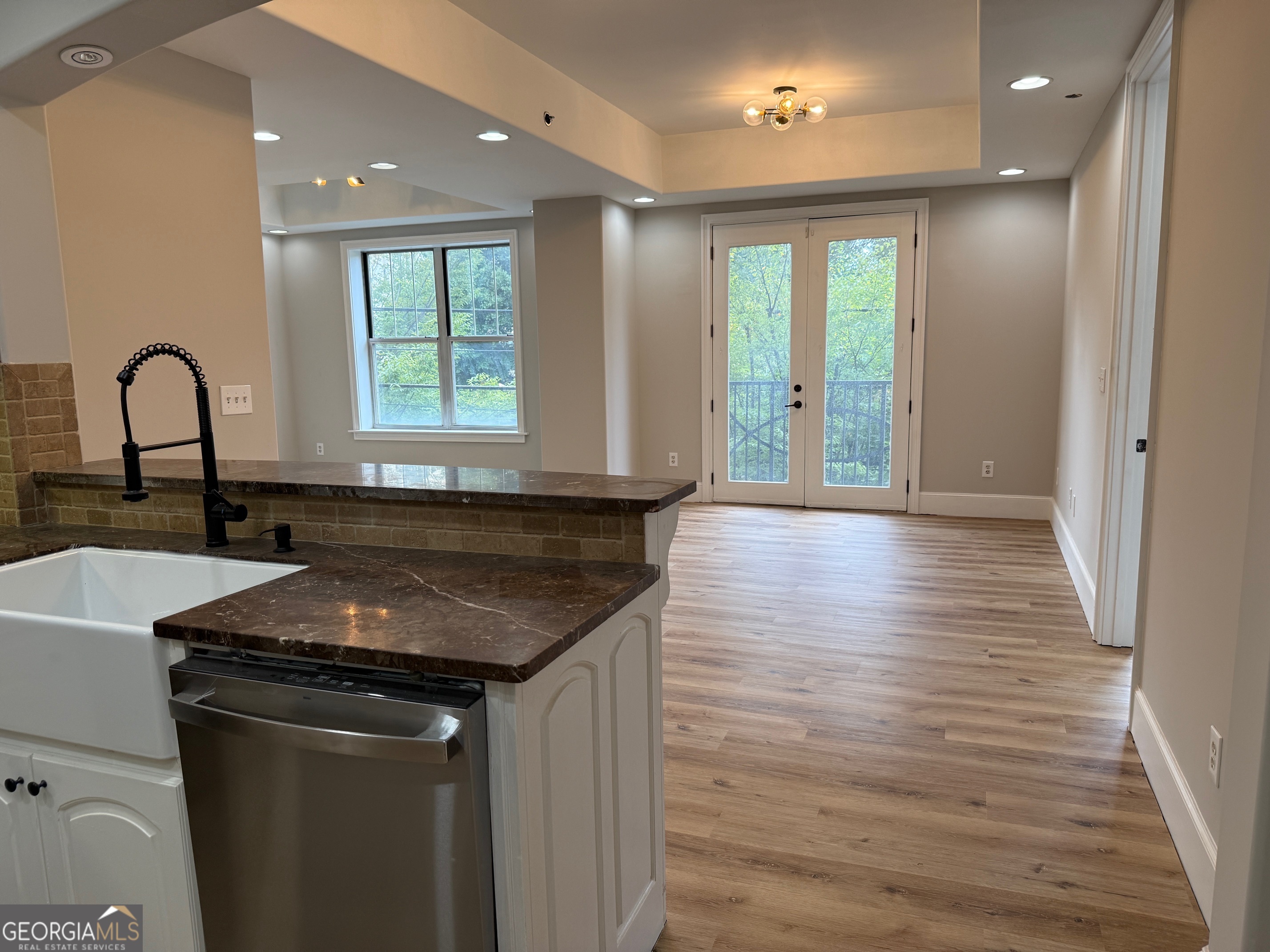 2255 Peachtree Road Northeast, Unit 322 Atlanta, GA 30305 - Photo 9 of 31 a kitchen with granite countertop wooden floors a sink and a window
