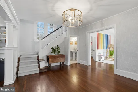 a view of an entryway with wooden floor windows and a chandelier