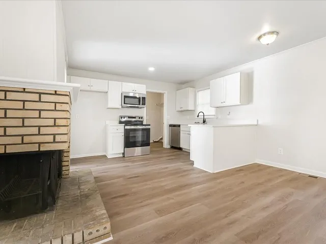 a view of a kitchen with a sink stove cabinets and empty room