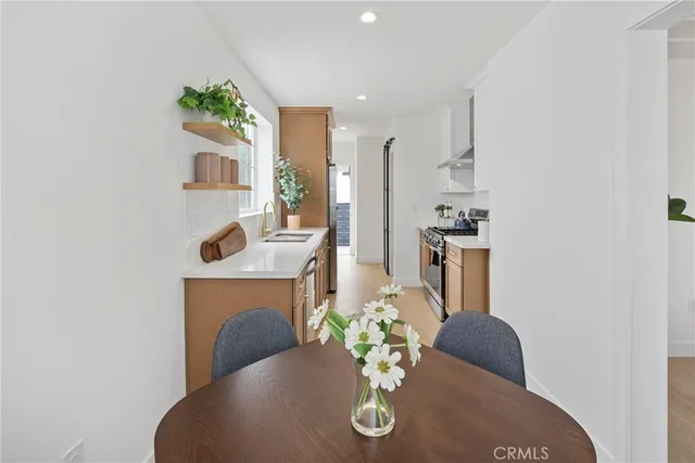 a living room with furniture potted plant and kitchen view