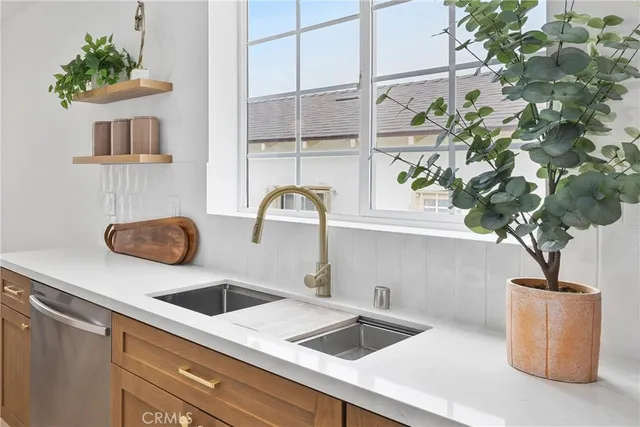 a kitchen with a potted plant on the granite counter tops and a wooden floor