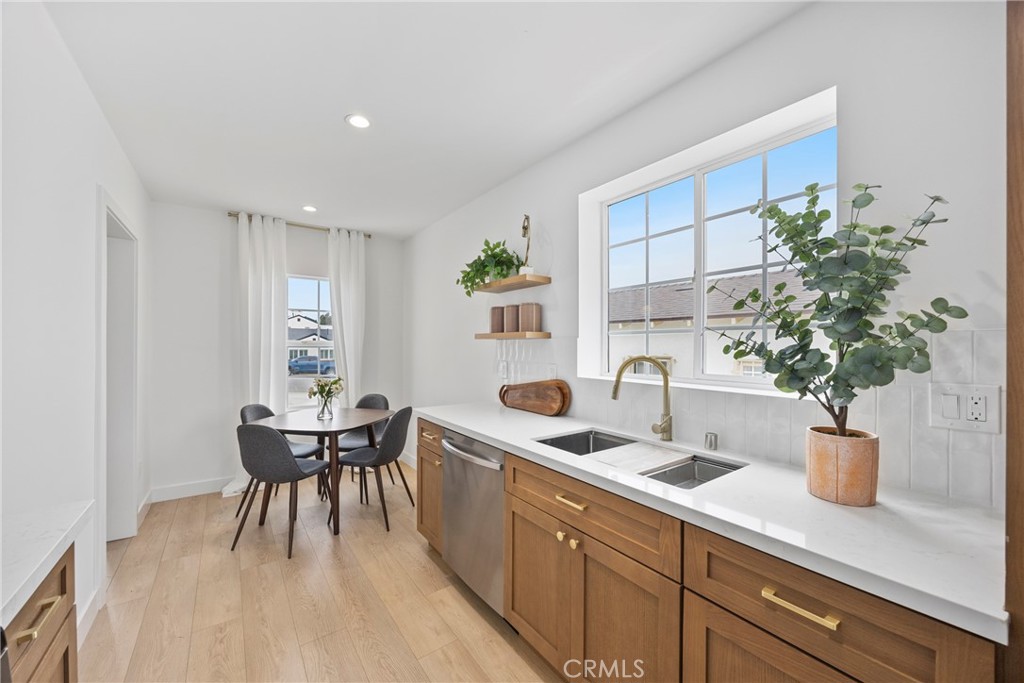 4254 West 58th Place Los Angeles, CA 90043 - Photo 15 of 53 a kitchen with a potted plant on the granite counter tops and a wooden floor