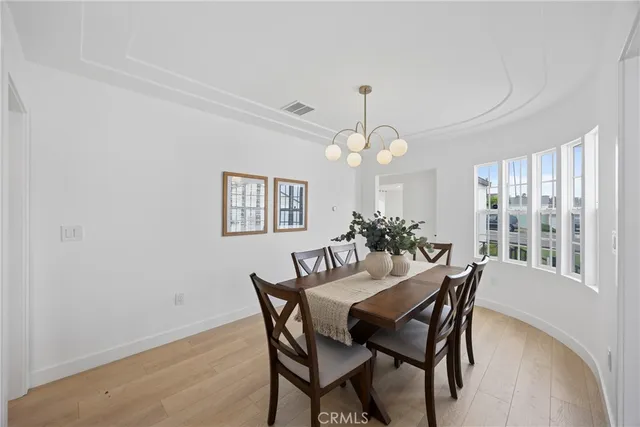 a view of a dining room with furniture a chandelier and wooden floor