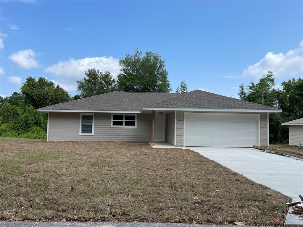 8829 East Marvin Street Floral City, FL 34436 - Photo 1 of 12 a front view of a house with yard and trees