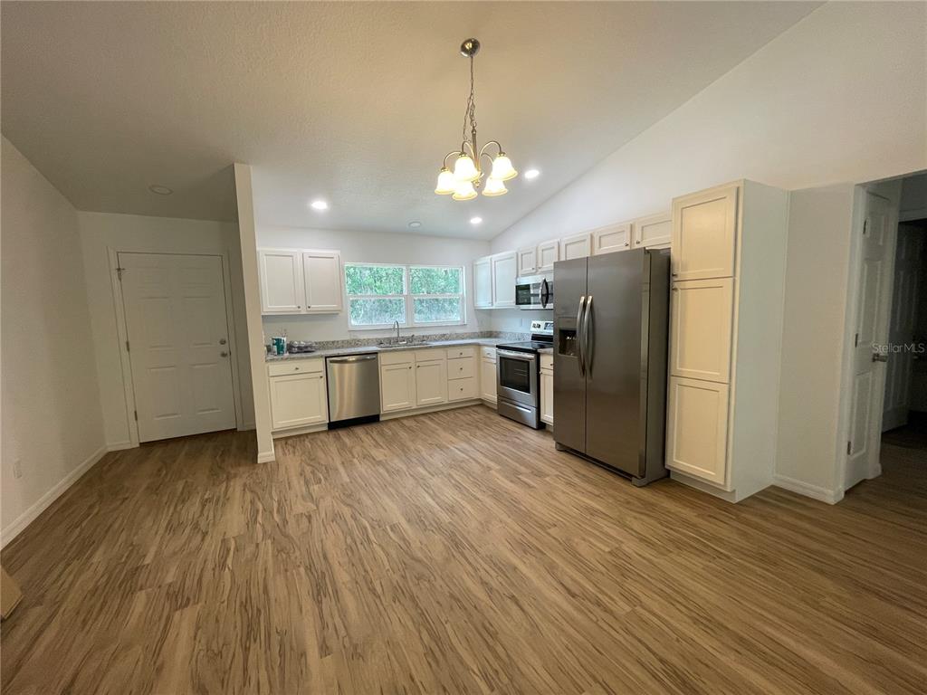 8829 East Marvin Street Floral City, FL 34436 - Photo 2 of 12 a kitchen with stainless steel appliances granite countertop a refrigerator a stove and a wooden floors