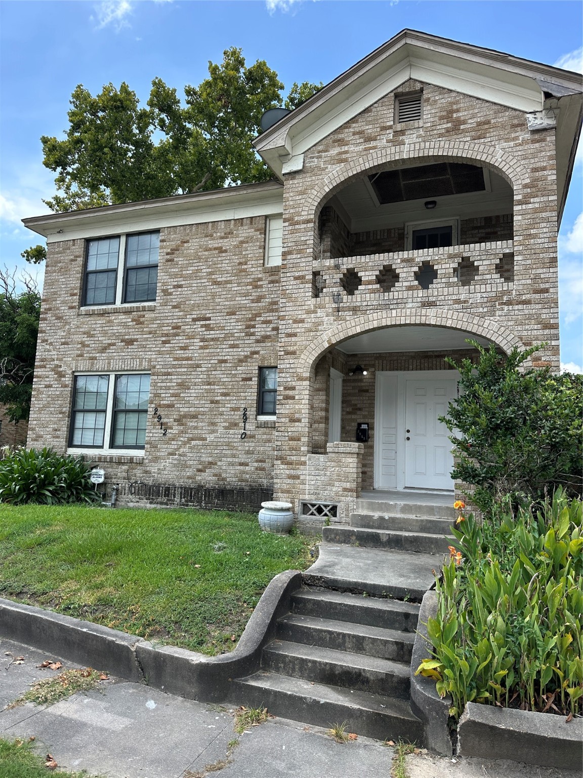 a front view of a house with a garden