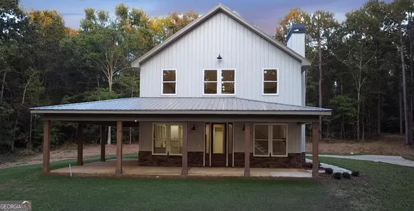 a view of a house with a yard and sitting area