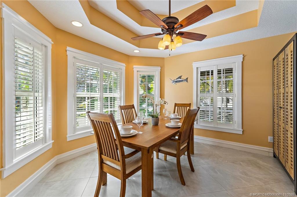 655 Southwest Salerno Road Stuart, FL 34997 - Photo 20 of 84 a dining room with furniture a chandelier and a large window
