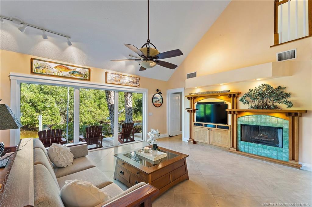 655 Southwest Salerno Road Stuart, FL 34997 - Photo 30 of 84 a living room with furniture a fireplace and a flat screen tv