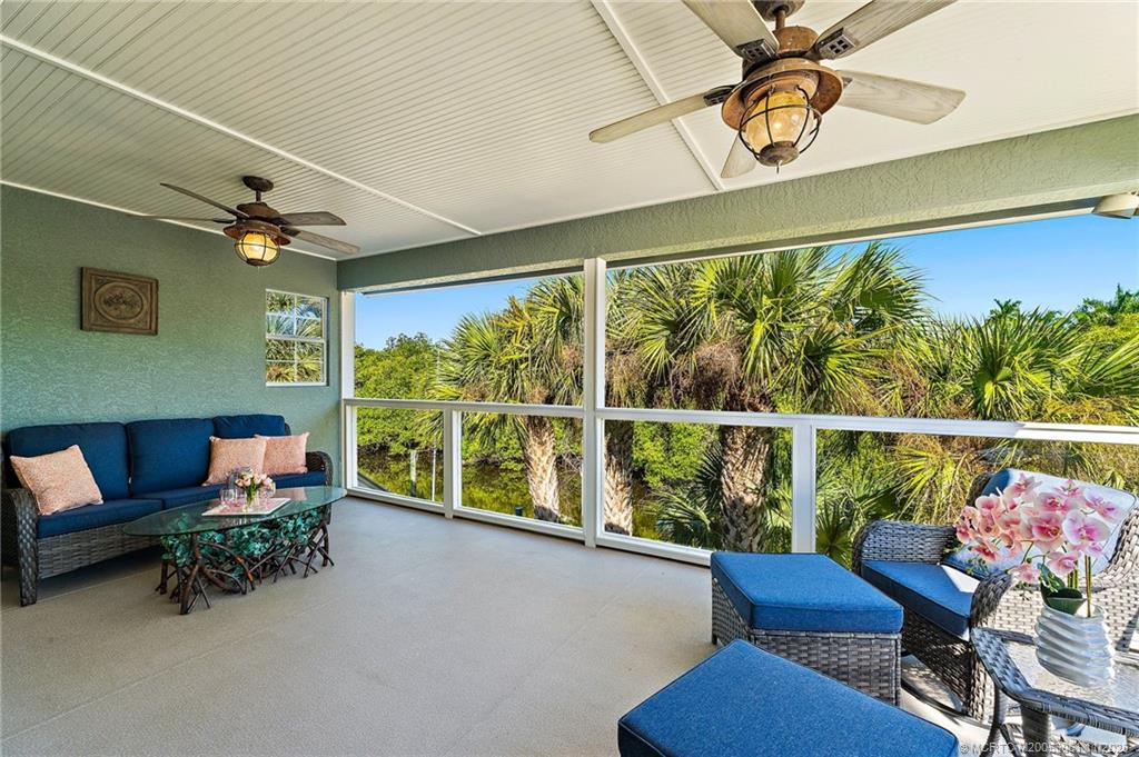 655 Southwest Salerno Road Stuart, FL 34997 - Photo 49 of 84 a living room with furniture and a floor to ceiling window