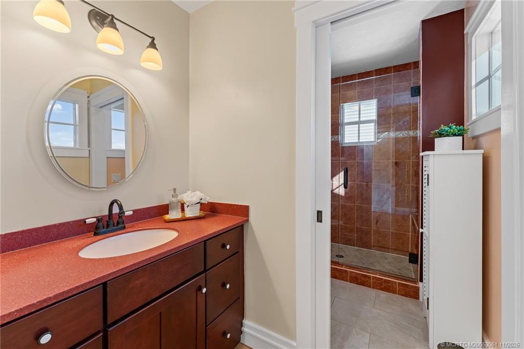 655 Southwest Salerno Road Stuart, FL 34997 - Photo 52 of 84 a bathroom with a sink a mirror a vanity and shower
