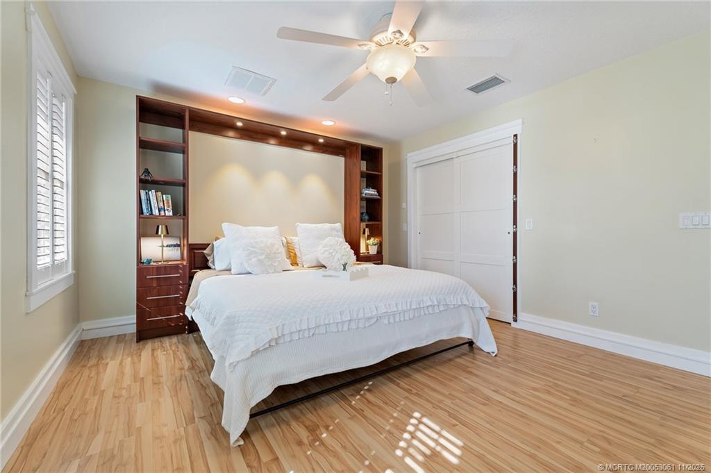 655 Southwest Salerno Road Stuart, FL 34997 - Photo 53 of 84 a bedroom with a large bed window and a ceiling fan