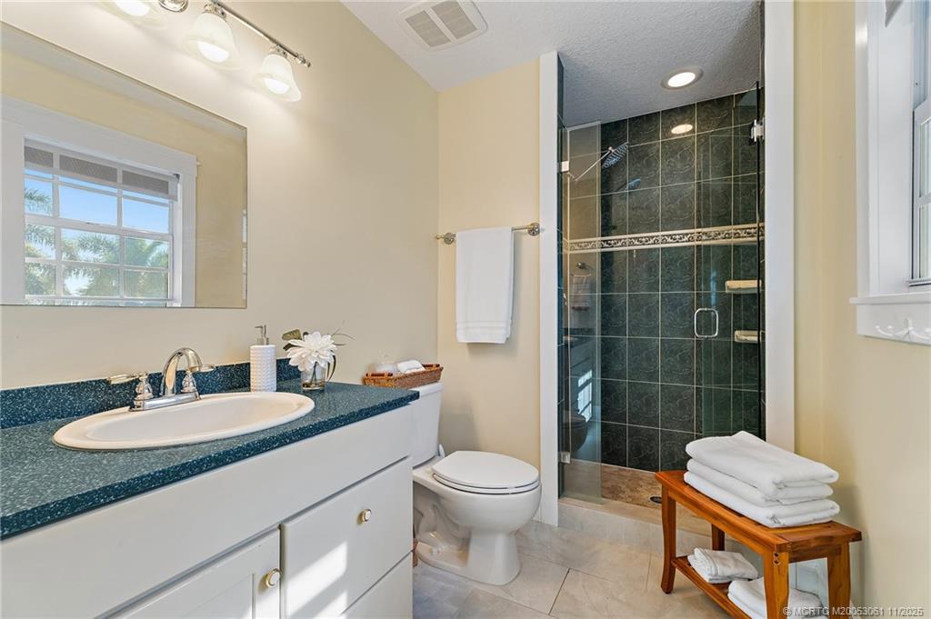 655 Southwest Salerno Road Stuart, FL 34997 - Photo 56 of 84 a bathroom with a sink toilet a mirror and shower
