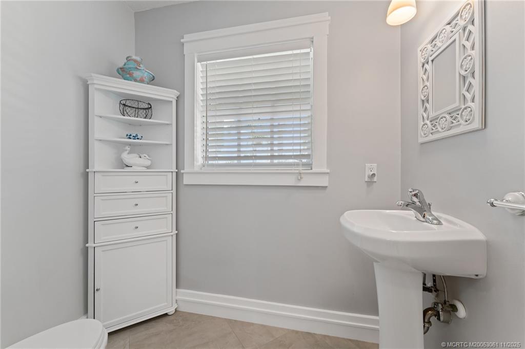 655 Southwest Salerno Road Stuart, FL 34997 - Photo 58 of 84 a bathroom with a sink a mirror and a window