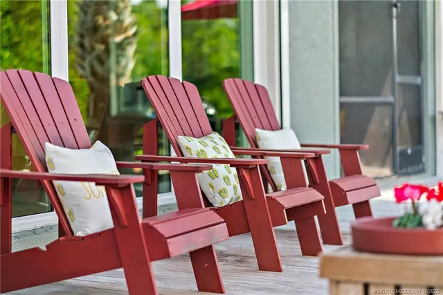 a dining room with furniture a chandelier and a large window