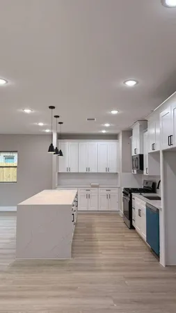 a large white kitchen with lots of counter top space a sink and appliances