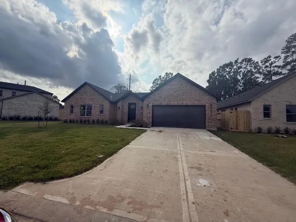 a front view of a house with a garden and yard