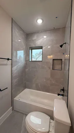 a bathroom with a toilet and a bath tub