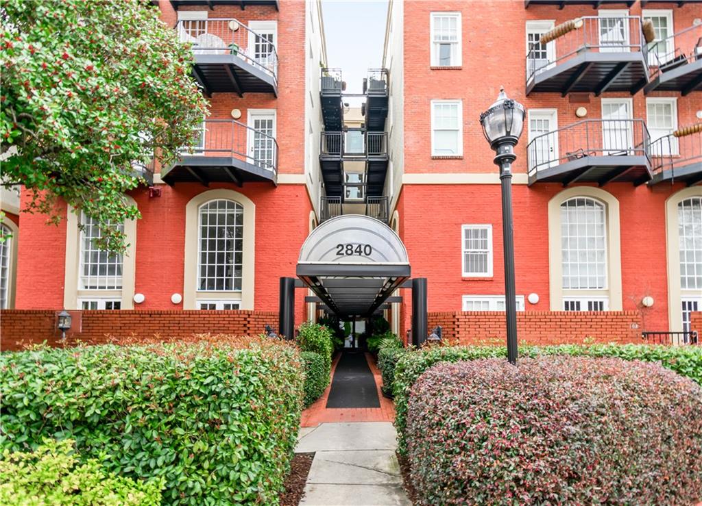 2840 Peachtree Road Northwest, Unit 312 Atlanta, GA 30305 - Photo 2 of 42 a view of a brick house with a clock and a pathway