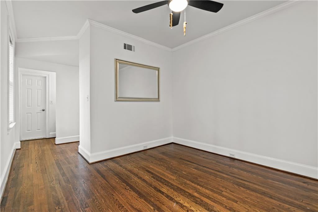 2840 Peachtree Road Northwest, Unit 312 Atlanta, GA 30305 - Photo 34 of 42 an empty room with wooden floor chandelier fan and windows