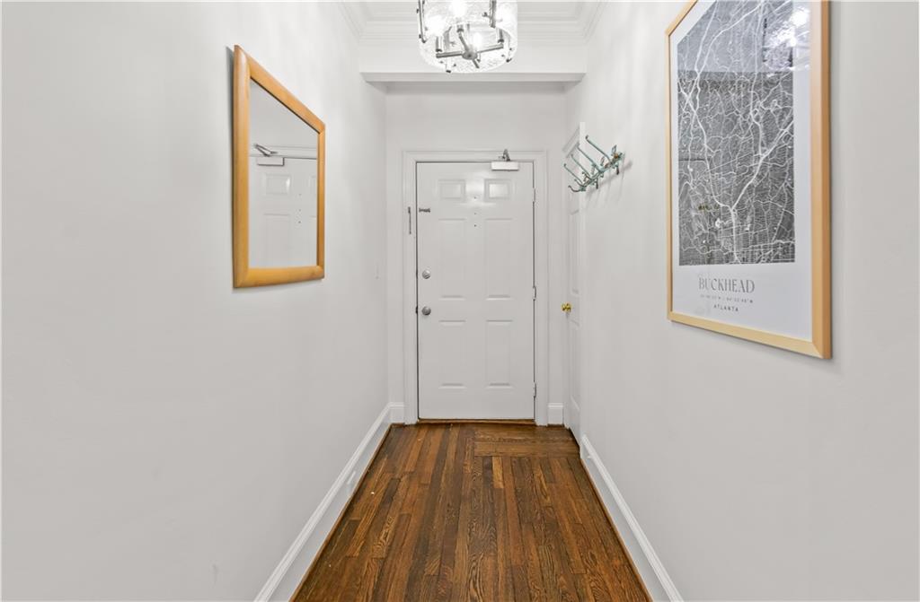 2840 Peachtree Road Northwest, Unit 312 Atlanta, GA 30305 - Photo 5 of 42 a view of a hallway with wooden floor and a chandelier