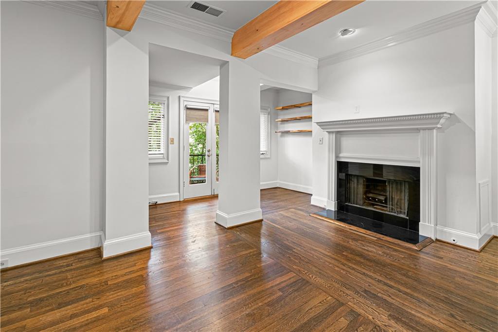 2840 Peachtree Road Northwest, Unit 312 Atlanta, GA 30305 - Photo 8 of 42 a view of an empty room with wooden floor fireplace and a window