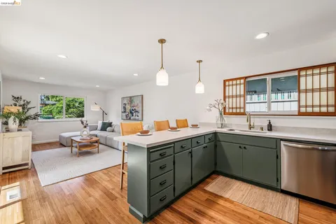 a kitchen with a sink and living room view
