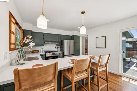 a dining room with furniture a chandelier and wooden floor