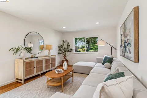 a living room with furniture a window and wooden floor