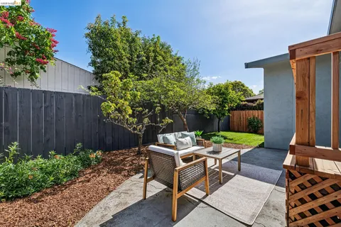 a backyard of a house with a garden and outdoor seating
