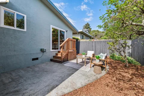 a view of a patio with table and chairs with wooden fence and plants