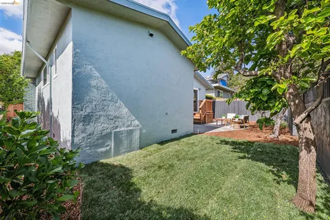 a backyard of a house with table and chairs plants