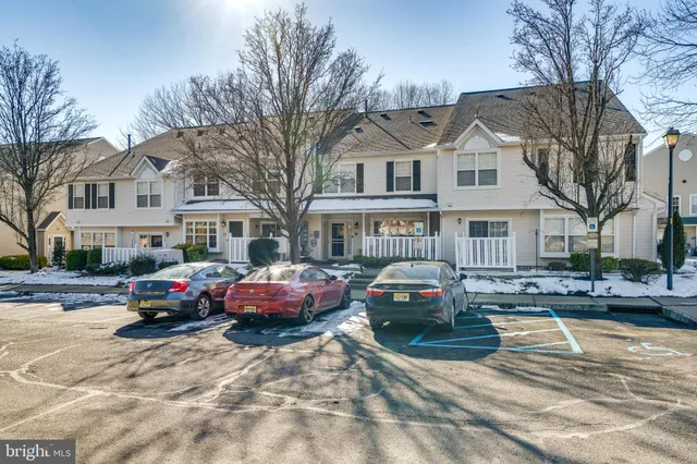 a front view of a house with cars parked